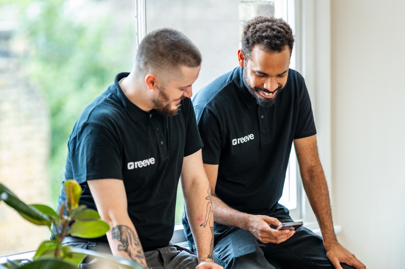 Two Reeve engineers on a break, looking at a phone together